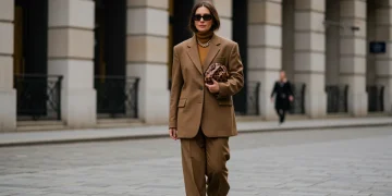 Woman in fall 2026 tailored oversized blazer and wide-leg trousers walking in a city.