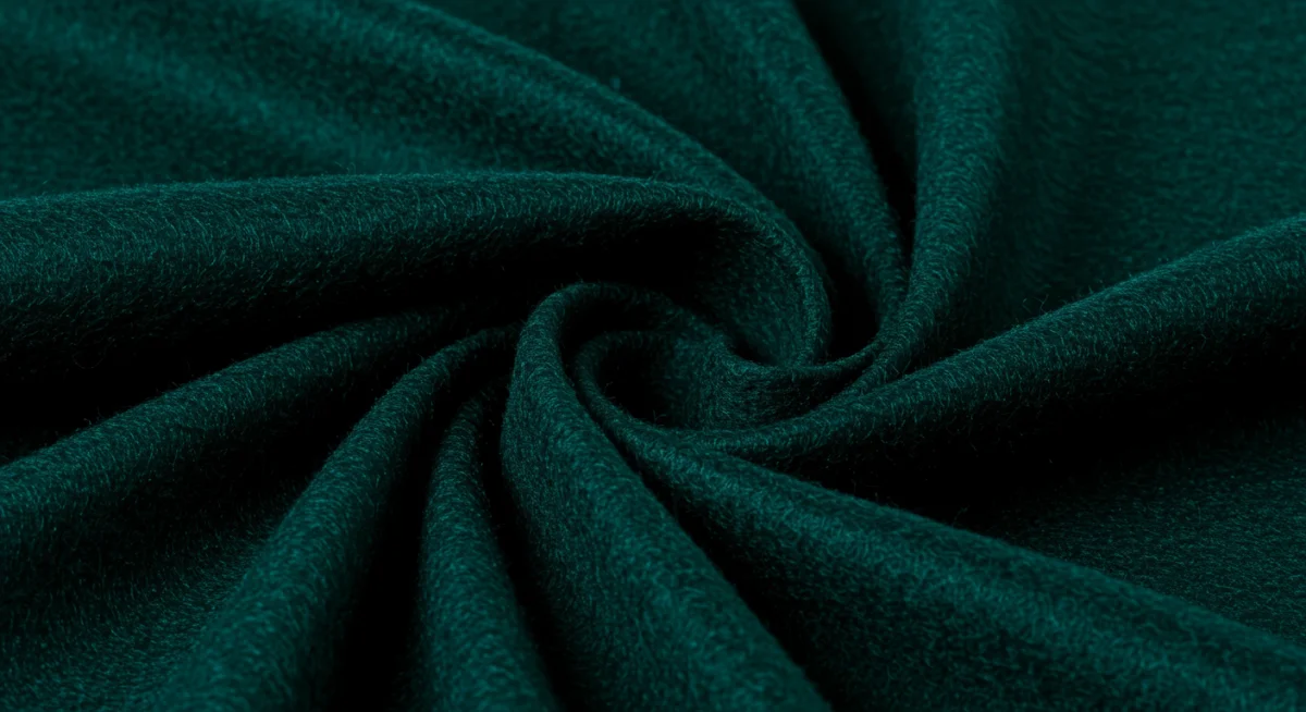 Close-up of luxurious textured fabric in deep jewel tone for fall 2026 fashion.